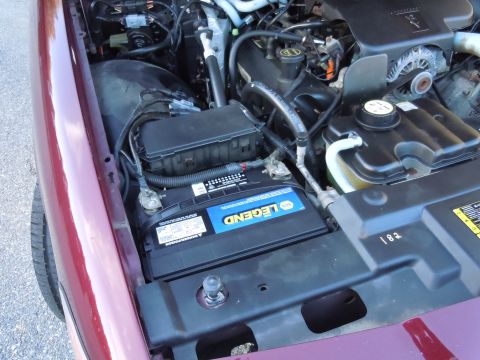 2001 Ford Crown Victoria - The engine bay of a vehicle, a prominent LEGEND brand battery and various engine parts.