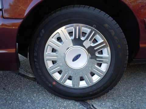 2001 Ford Crown Victoria - The wheel features a chrome hubcap with the Ford emblem, and the tire is a Goodyear Eagle.