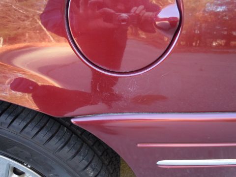2001 Ford Crown Victoria - Close-up of the rear quarter panel and gas cap on a red 2001 Ford Crown Victoria.