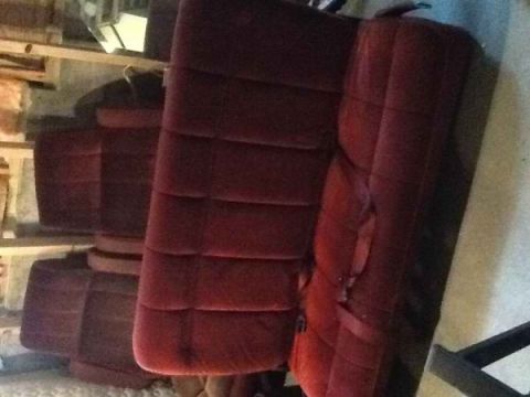 1985 Ford Bronco - Multiple rows of velour car seats are stored indoors, appearing to be from a vehicle.