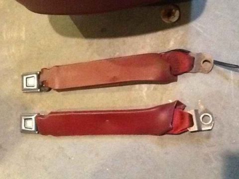 1985 Ford Bronco - Close-up view of two automotive seat belts, showing their buckles and attachment hardware.