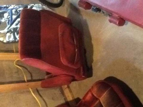 1985 Ford Bronco - Close-up view of red cloth car seats, showing their upholstery and structure.