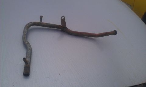 1991 Ford Festiva - This is a single metal pipe, likely a coolant or vacuum line, lying on a flat surface.