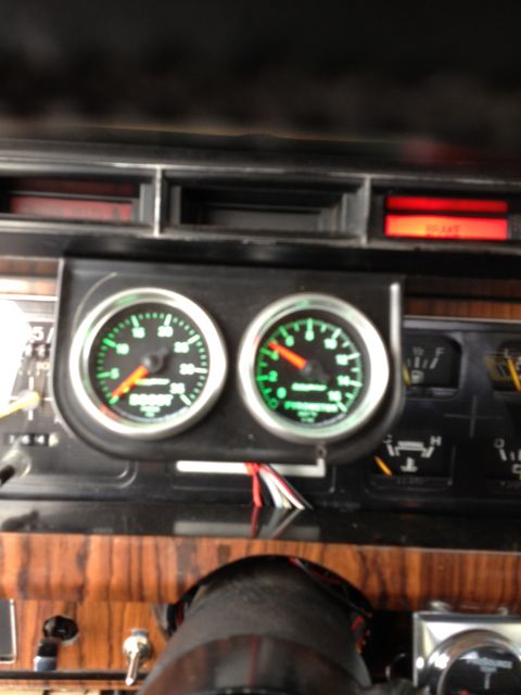 1984 Ford Bronco - Aftermarket gauges are installed on the dashboard, with the brake warning light illuminated.