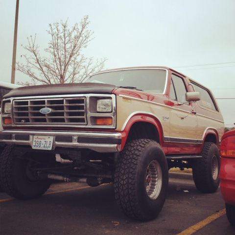 1984 Ford Bronco - This 1984 Ford Bronco is lifted and features a two-tone red and tan paint scheme.