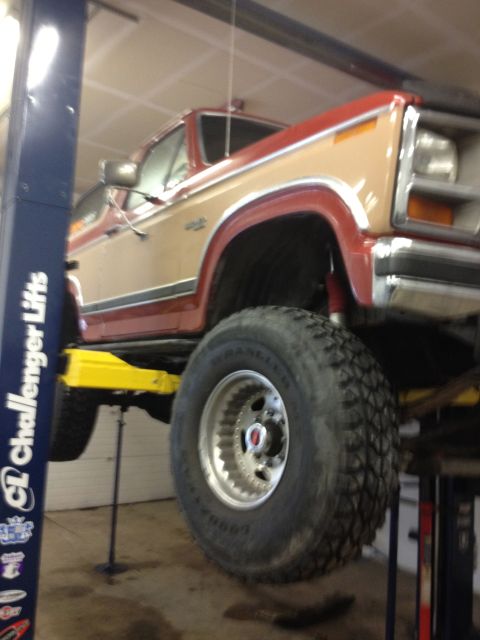 1984 Ford Bronco - Ford Bronco lifted for service, displaying its distinctive body style and off-road tires.