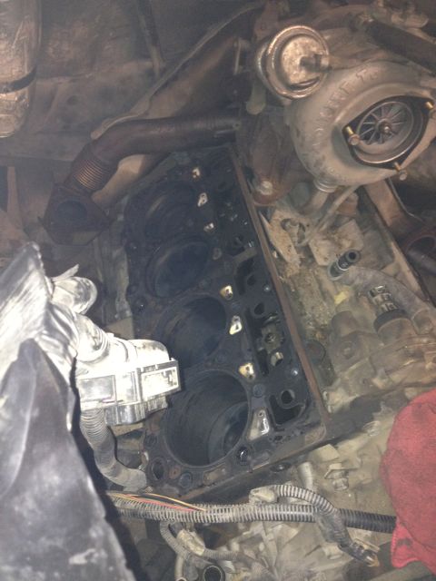 1984 Ford Bronco - Close-up view of a disassembled engine, showing the cylinder head removed and a turbocharger mounted above.