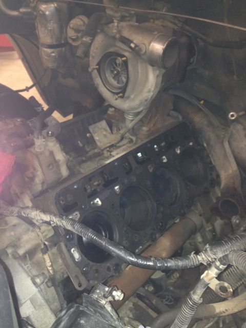1984 Ford Bronco - Close-up view of an engine block and turbocharger, likely during repair or disassembly.