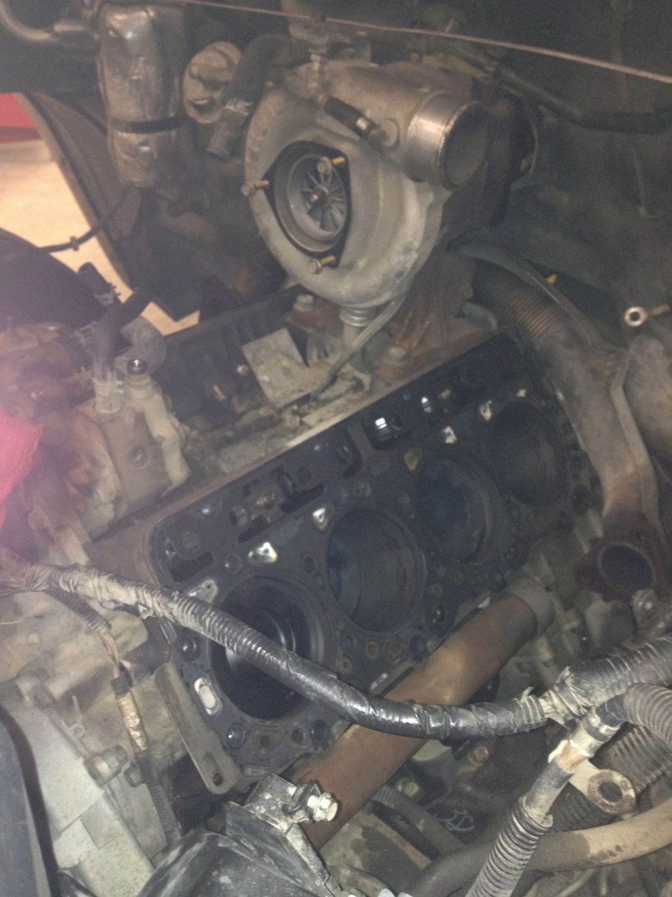 Engine block with cylinders exposed, turbocharger mounted above