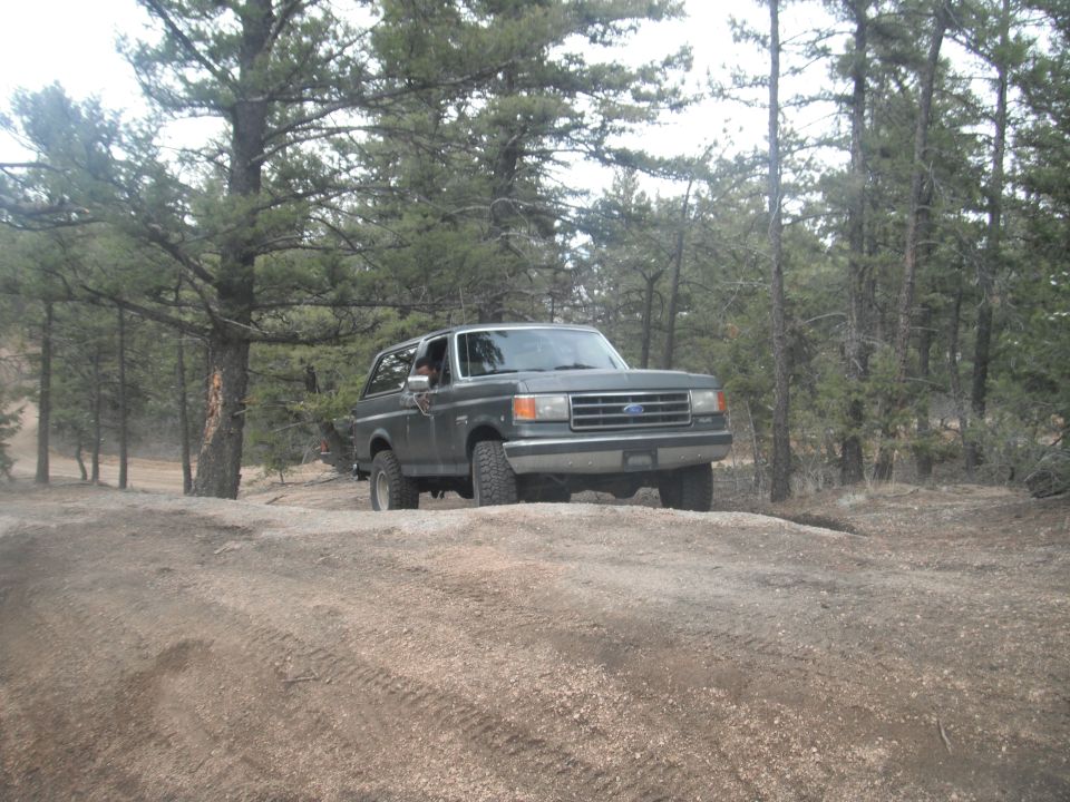 Dark gray 1990 Ford Bronco on a dirt road