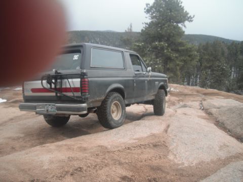1990 Ford Bronco - This 1990 Ford Bronco is navigating a rocky trail in a mountainous, wooded area.
