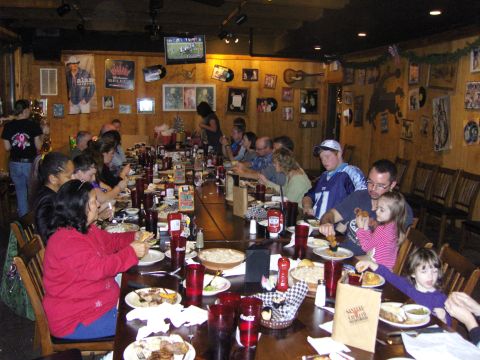 2007 Ford Mustang - A group enjoys a meal together at a restaurant with wood-paneled walls and decorated with memorabilia.
