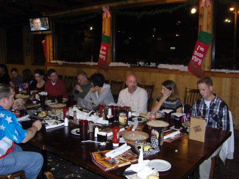 2007 Ford Mustang - A group of people are seated at a long table in a restaurant, with Christmas stockings hanging in the background.