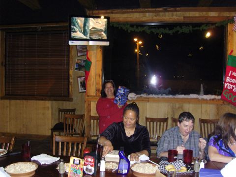 2007 Ford Mustang - A holiday party scene with people seated at a table and decorations in the background.