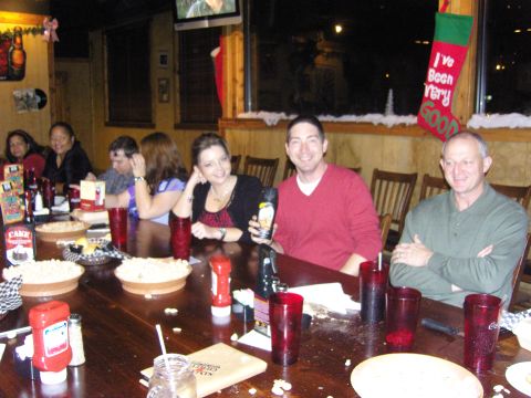 2007 Ford Mustang - A group of people enjoy a holiday gathering around a long table laden with food and drinks.