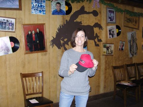 2007 Ford Mustang - Woman holds a baseball cap in front of a decorated wall with photos and records.