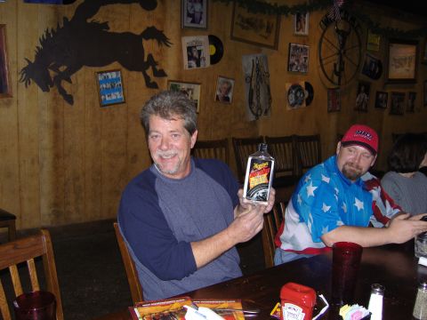 2007 Ford Mustang - A man proudly displays a bottle of Meguiar's car wax while seated at a table with others.
