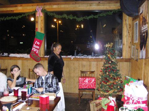 2007 Ford Mustang - A Christmas party scene with people, a decorated tree, and gifts.