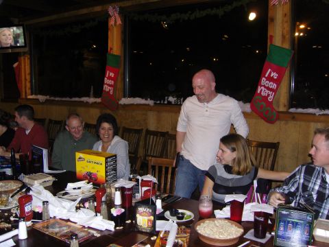 2007 Ford Mustang - A group of people are enjoying a holiday gathering around a table laden with food and drinks.