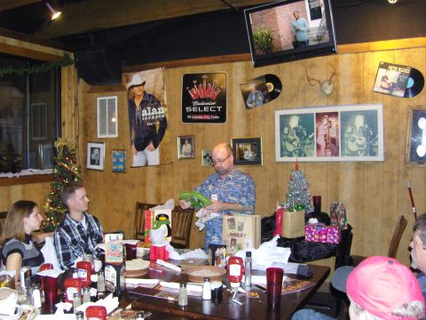 2007 Ford Mustang - A group of people are gathered around a table in a room decorated for the holidays, with gifts and a Christmas tree visible.