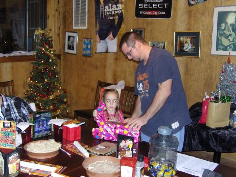 2007 Ford Mustang - A family celebrates Christmas, opening gifts around a table with food and decorations.