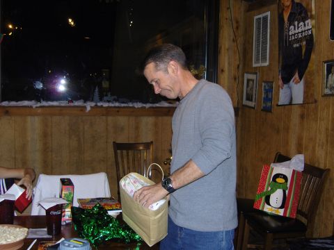 2007 Ford Mustang - A man opens a gift bag during a Christmas party, with festive decorations visible.