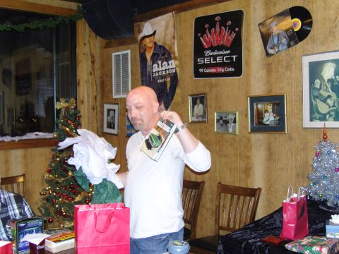 2007 Ford Mustang - A man holds a book a car at a holiday gathering, surrounded by festive decorations and memorabilia.