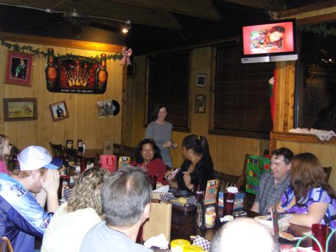 2007 Ford Mustang - A group of people are seated at tables in a restaurant, with a television displaying an image on the wall.