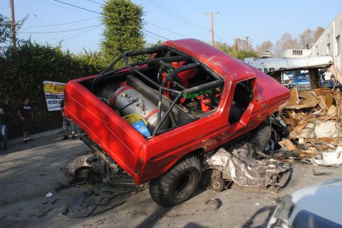 1978 Ford Bronco - A red off-road vehicle, possibly a Bronco, is heavily damaged and entangled with debris from a collision.