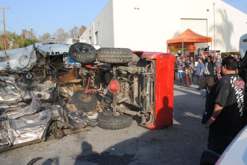 1978 Ford Bronco - A crowd gathers to observe the aftermath of a severe vehicle accident involving an overturned SUV and a crushed car.