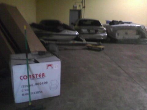 2003 Ford Crown Victoria - Several vehicles are stored inside a garage, with a box in the foreground.