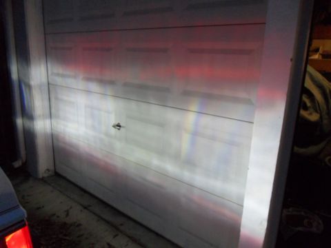 1994 Jeep Cherokee - Headlights illuminate a garage door, creating colorful light patterns on the surface.