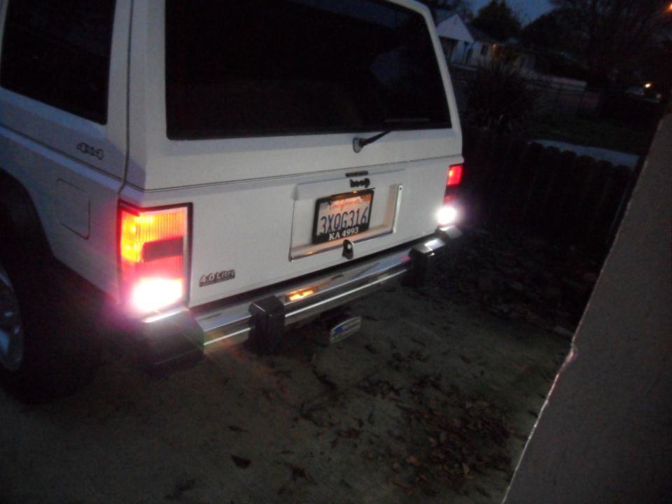 White Jeep Cherokee rear view, chrome bumper, license plate 3XOG316