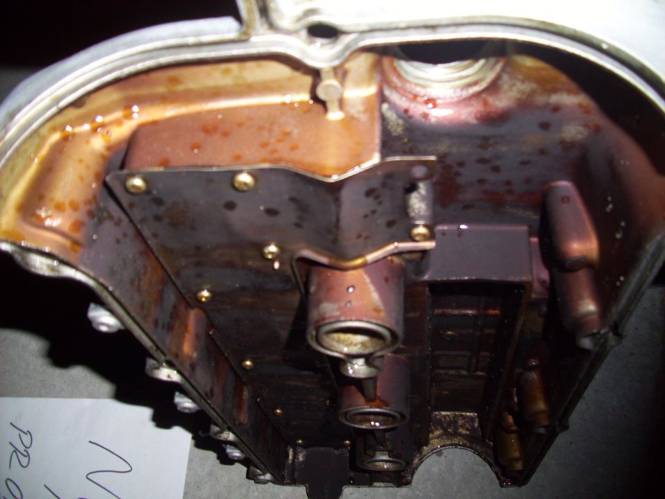Interior of a dirty engine valve cover with oil residue
