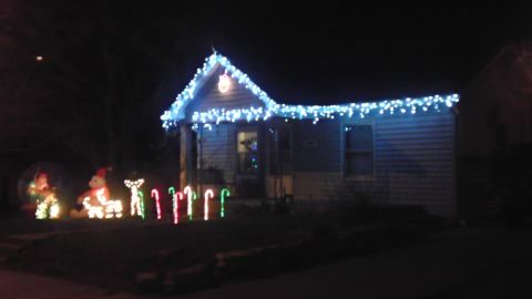 1989 Ford Bronco - A house is decorated for Christmas with blue lights and lawn ornaments.