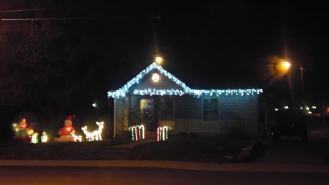 1989 Ford Bronco - A house is decorated with blue Christmas lights and inflatable figures on the lawn.