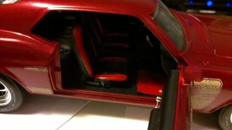1970 Ford Mustang - A detailed view of the interior of a red 1970 Ford Mustang model, showing the seats and door panel.