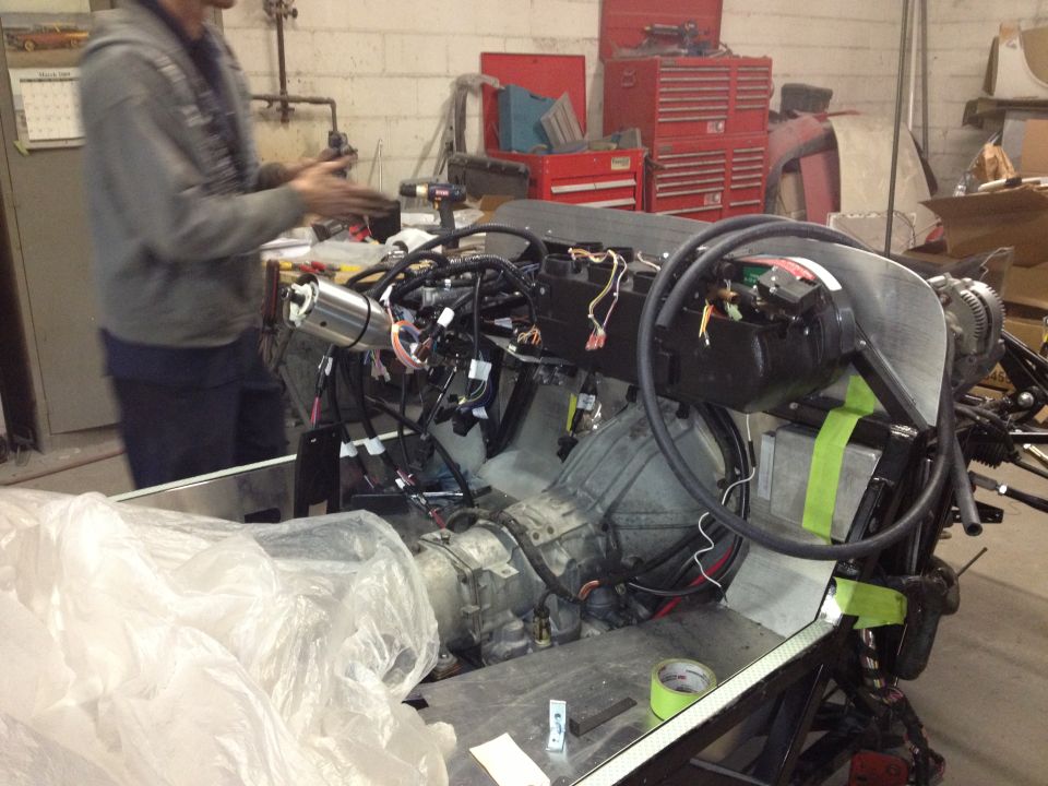 Engine and transmission assembly with wiring harness and hoses, on a workbench
