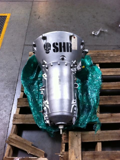 2010 Dodge Challenger - A silver transmission with the SHR logo is shown on a wooden pallet, wrapped in green protective material.