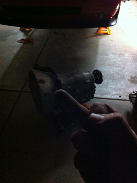 2010 Dodge Challenger - Transmission part on the ground, with a red car above it on jack stands.