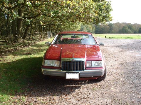 1992 Lincoln Mark VII - Front view of a red 1992 Lincoln Mark VII parked on a gravel surface.