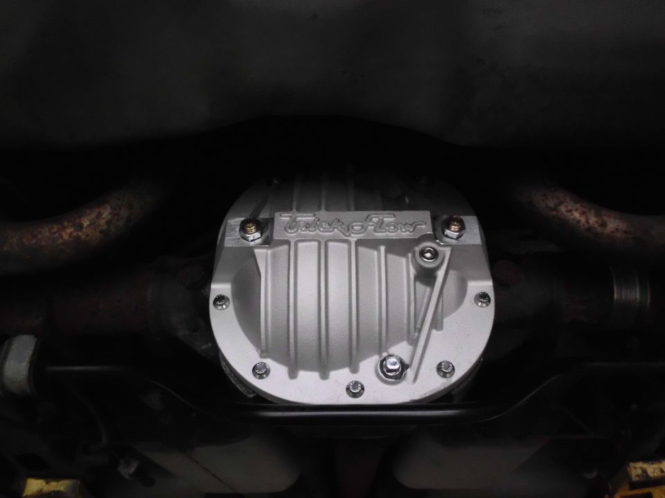 Trick Flow finned aluminum differential cover on rear axle, viewed from under the car