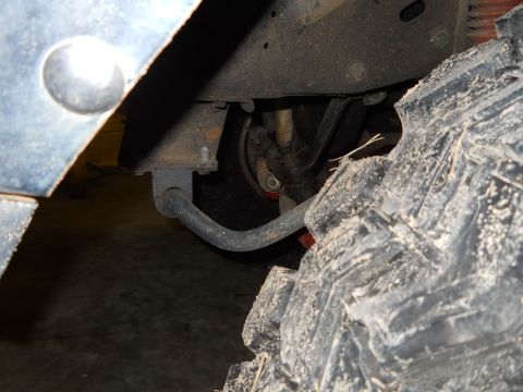1992 Ford Bronco - A close-up view of a vehicle's suspension system and a large off-road tire, with a watermark from SuperMotors.net visible.