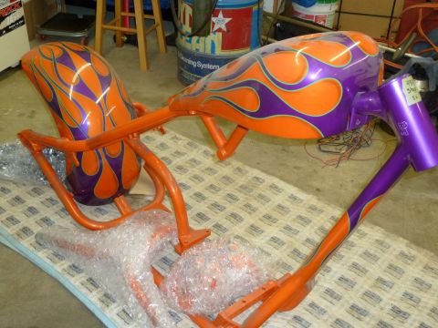 1992 Ford Mustang - Custom painted motorcycle frame and fenders with flame graphics are laid out on a patterned drop cloth.