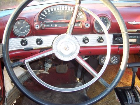 1956 Ford Thunderbird - The dashboard of a 1956 Ford Thunderbird shows its classic interior design with a prominent steering wheel and instrument cluster.