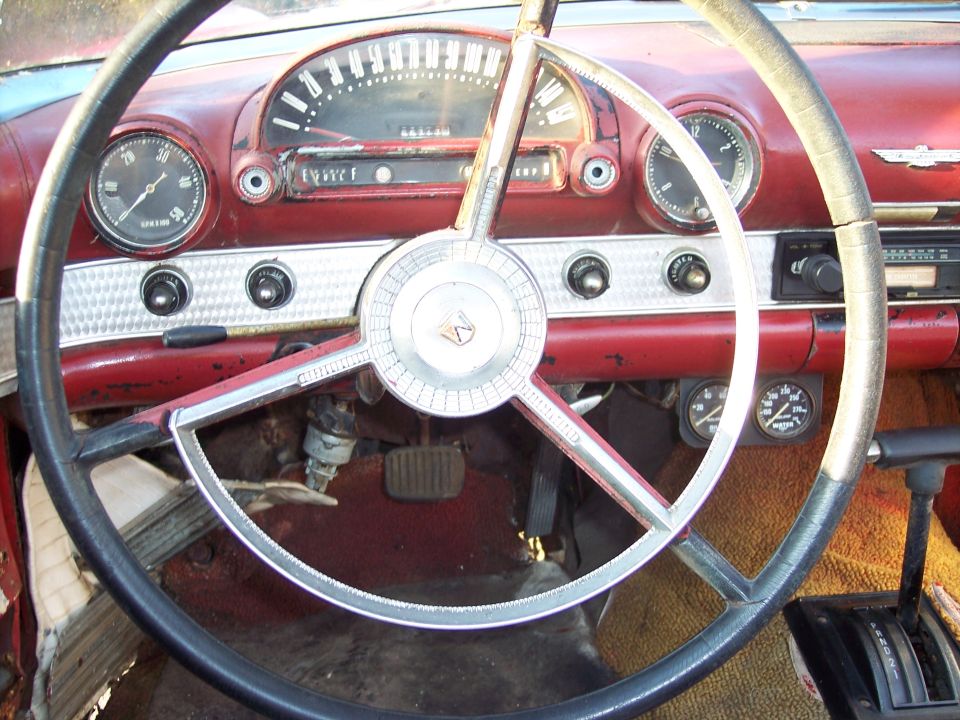 1956 Ford Thunderbird interior dashboard with red trim, large steering wheel, and gauges