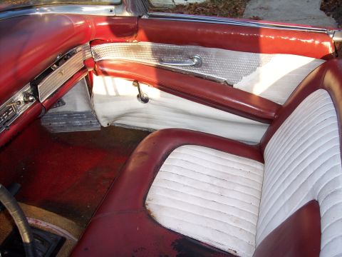 1956 Ford Thunderbird - The interior of a 1956 Ford Thunderbird features red and white upholstery and distinctive door panels.