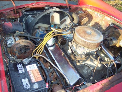 1956 Ford Thunderbird - Close-up view of a V8 engine bay with various components visible.