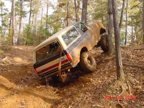 1989 Ford Bronco - This 1989 Ford Bronco navigates a challenging off-road course, its tires gripping the muddy terrain.