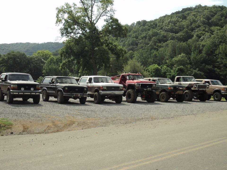 Line of SUVs and trucks parked side-by-side, mostly Ford Broncos and F-Series trucks